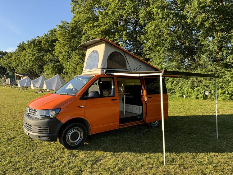 The actual orange Van Tropez Volkswagen T6 with its pop-top and awning open